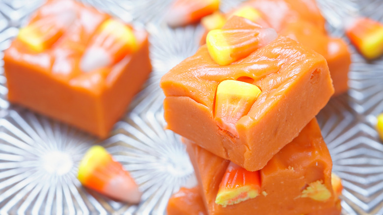 A close-up of orange-colored fudge slices with candy corn on top