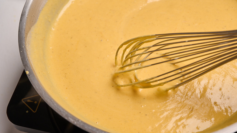 whisking sauce together in skillet