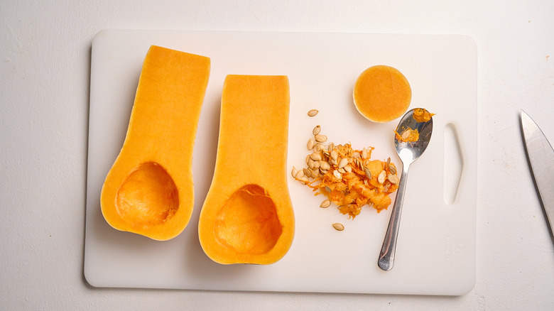 scooping the seeds out of butternut squash