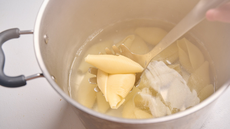 lifting cooked pasta out of water