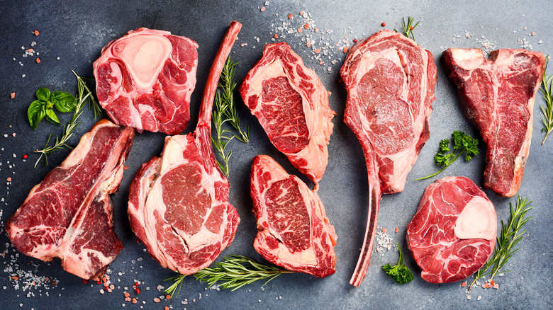 variety of raw steak cuts with salt and herbs