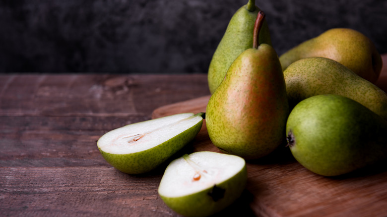 Several whole pears and one that has been sliced in half