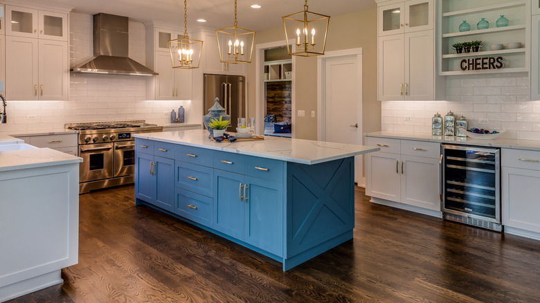 Modern kitchen featuring a blue kitchen island with a stone countertop