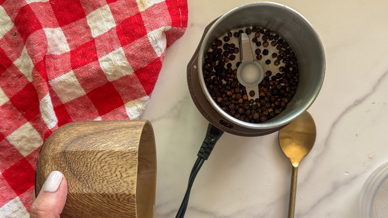 Black peppercorns in spice grinder