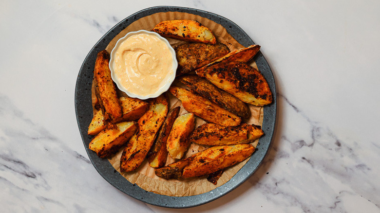 Steak fries into aioli on a plate