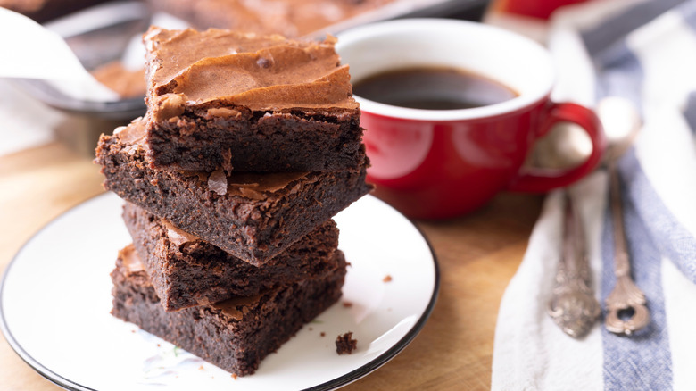 stack of brownies with a coffee mug