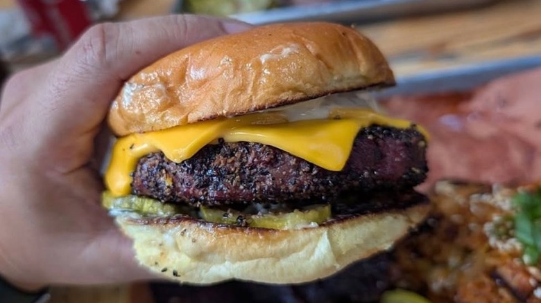 man holding thick burger