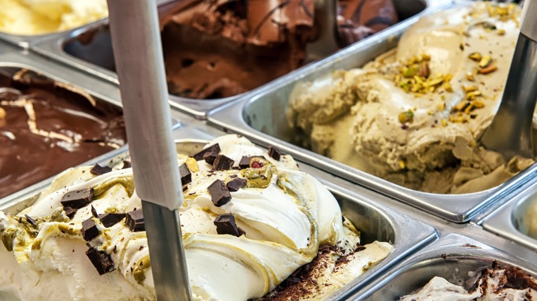 A close up image of multiple flavors in a a case in an ice cream shop.
