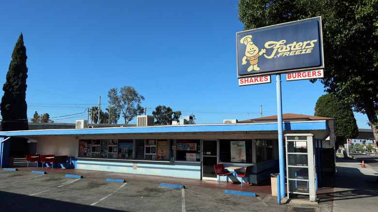 The exterior of a Fosters Freeze location with a sign advertising shakes and burgers