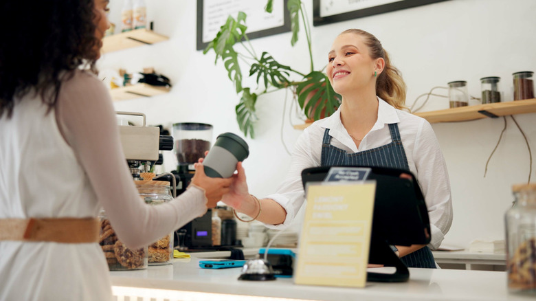 Barista handing a patron their coffee order