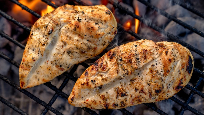 Top-down view of two cooked chicken breasts on a grill