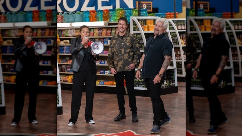 Guy Fieri and guest judges standing in Guy's Flavortown Market