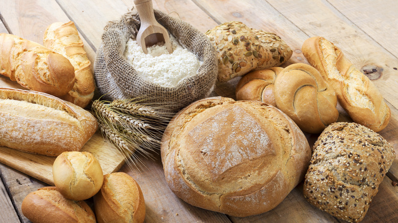 Variety of bread around bag of flour