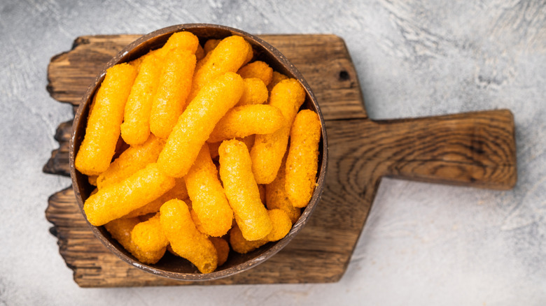 Cheetos Puffs in bowl on wood board