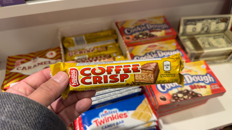 Hand holding a package of a Nestlé Coffee Crisp chocolate bar at the store