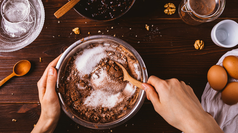 Top view hands mix sugar and flour to make homemade cake