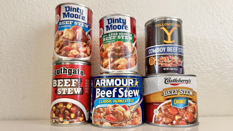 Close-up photo of various beef stew cans on a table.