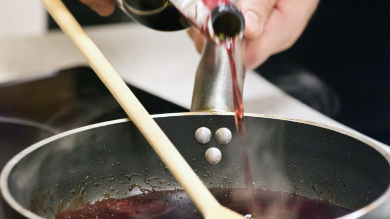 pouring wine into a cooking pot