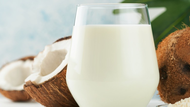 Close-up of a glass of fresh coconut milk and coconuts