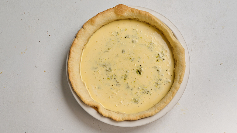 pesto and egg filling in a baked pie crust