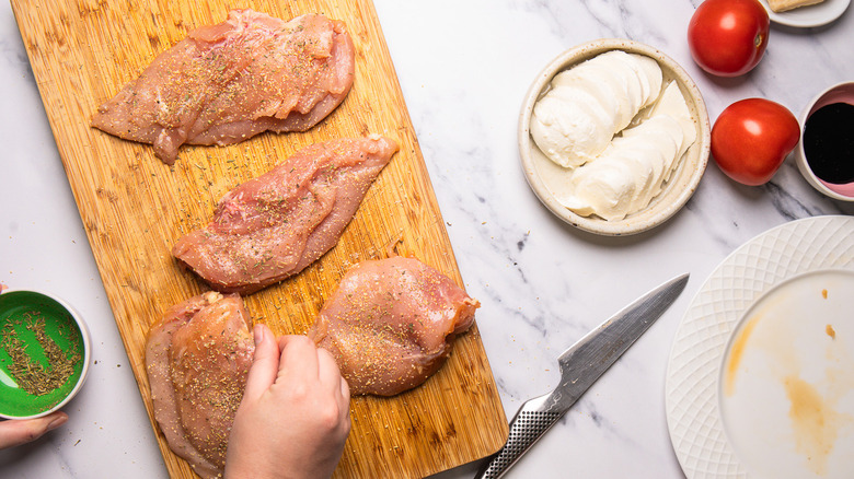 Seasoning raw chicken breasts