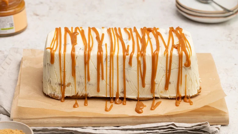A caramel apple icebox cake sits on parchment paper on a countertop.
