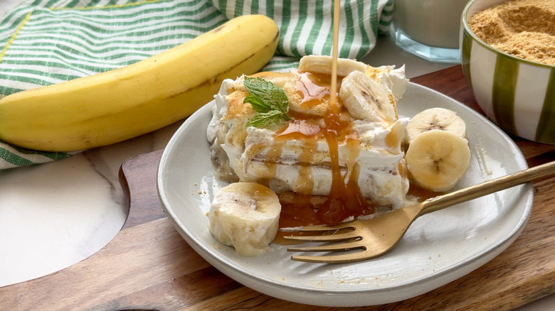 drizzling caramel sauce onto banana icebox cake slice