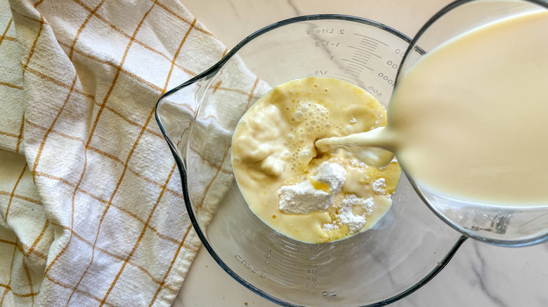 pouring milk into a bowl with pudding mix