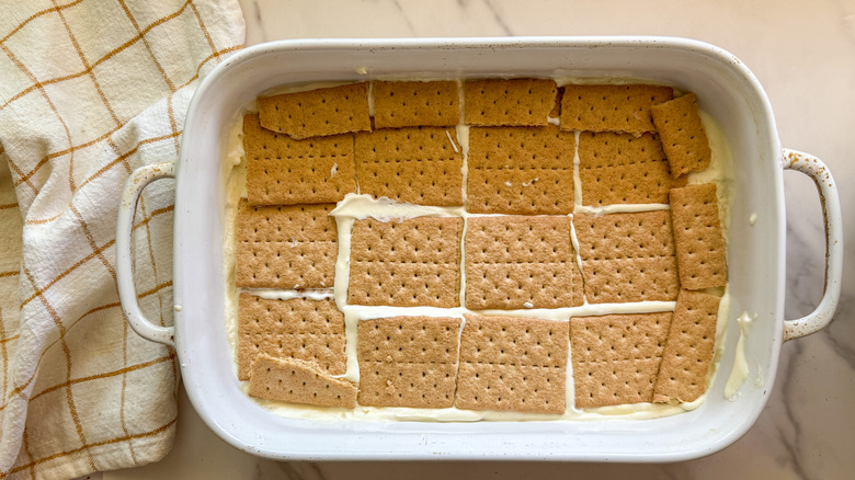 graham crackers layered onto pudding in baking dish