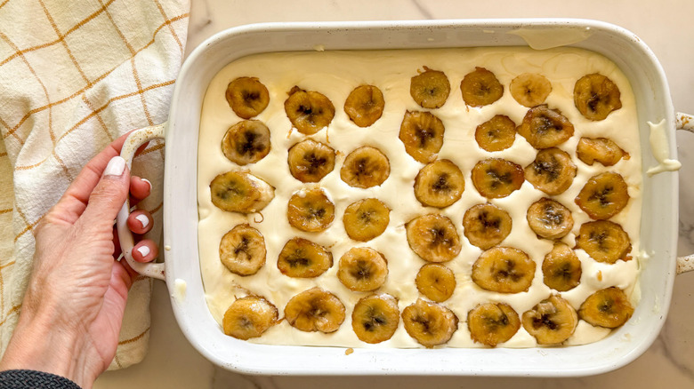 caramelized bananas layered on top of pudding in baking dish