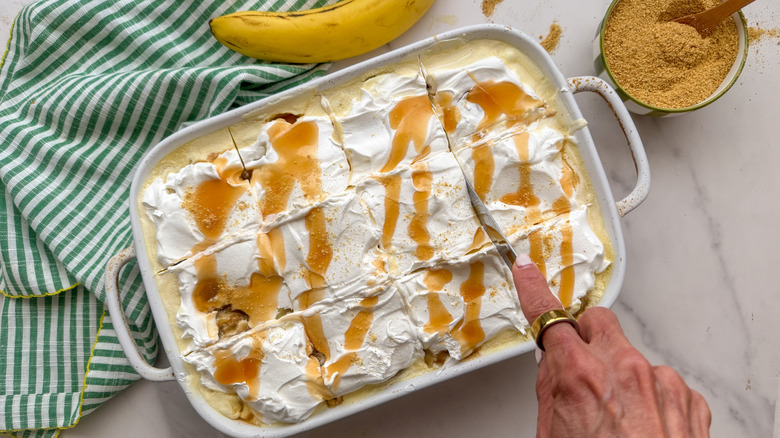 hand slicing caramel banana icebox cake