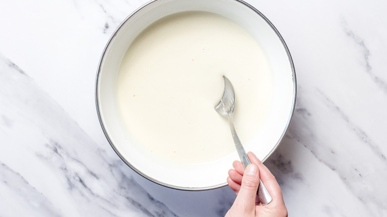 Running a spoon through custard in bowl