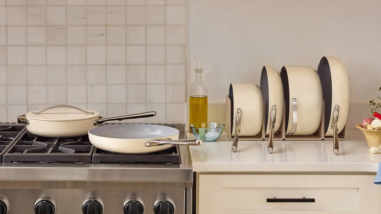 Caraway ceramic nonstick cookware set up on counter and stove.