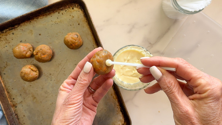 hands inserting stick into pop