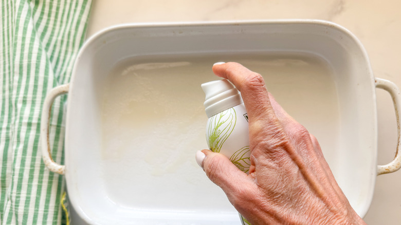 hand spraying baking pan