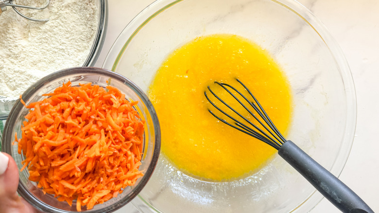hand adding carrots