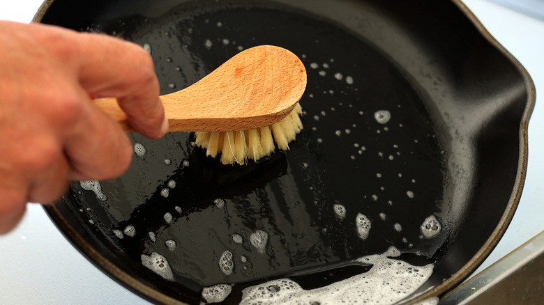 Hand cleaning cast iron skillet