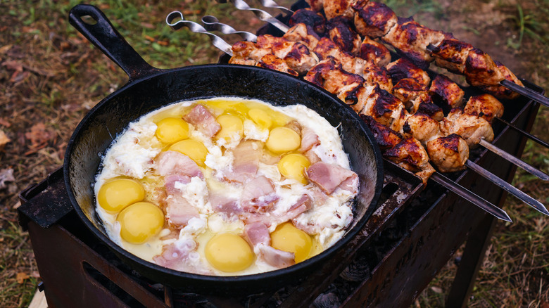 cast iron pan with eggs on outside grill