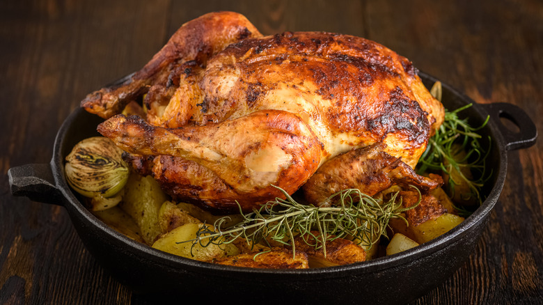 Whole roasted chicken, charred vegetables, cast iron skillet