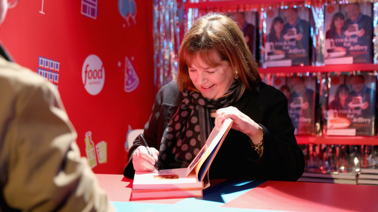 Ina Garten signing her cookbook for a fan