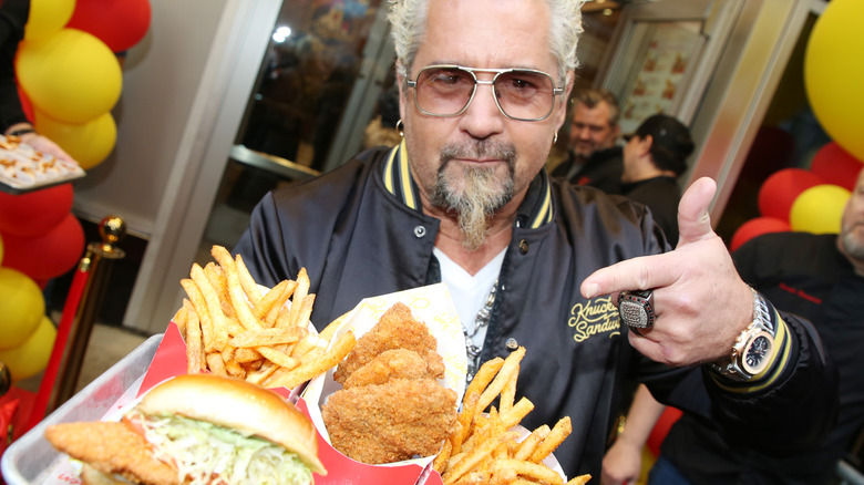 Guy Fieri posing with plate of food