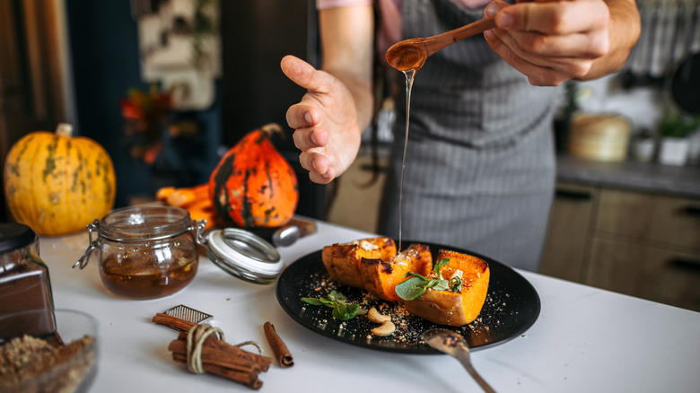 A young man prepares a colorful fall squash dish in a home kitchen