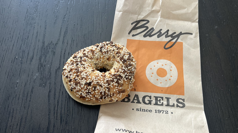 Barry Bagels everything bagel on take out bag on a darkk table