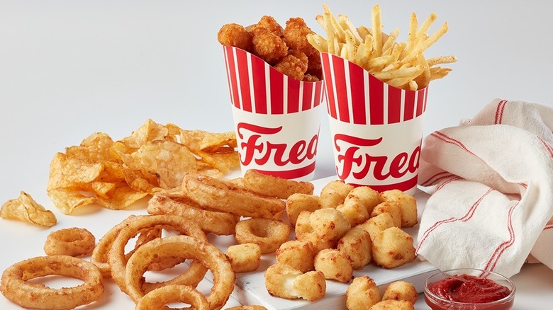 Freddy's sides of onion rings, cheese curds, fries, chips, and tater tots