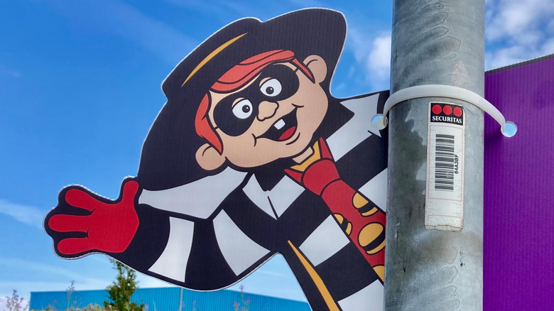 Hamburglar cut out stuck to a pole in front of blue sky