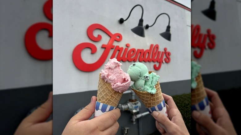 Ice cream cones clinking together in front of a Friendly's wall sign