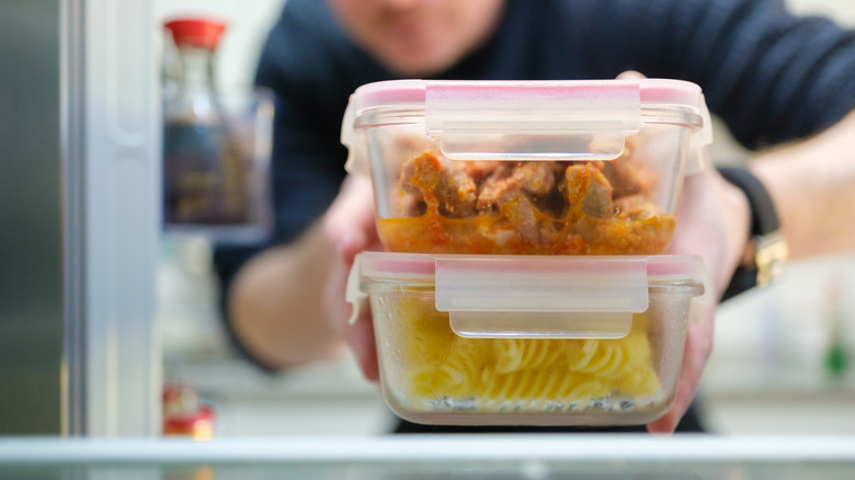 Person getting leftovers out of a fridge
