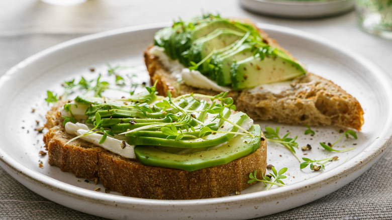 white plate of avocado toast slies