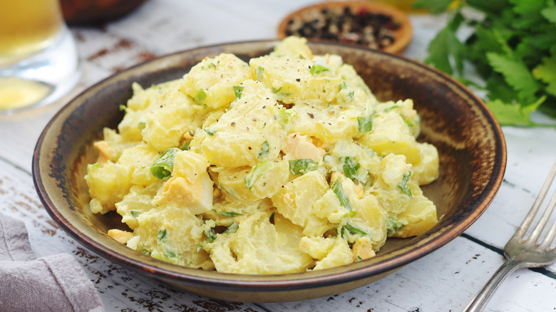 View of creamy potato salad in a bowl on a table