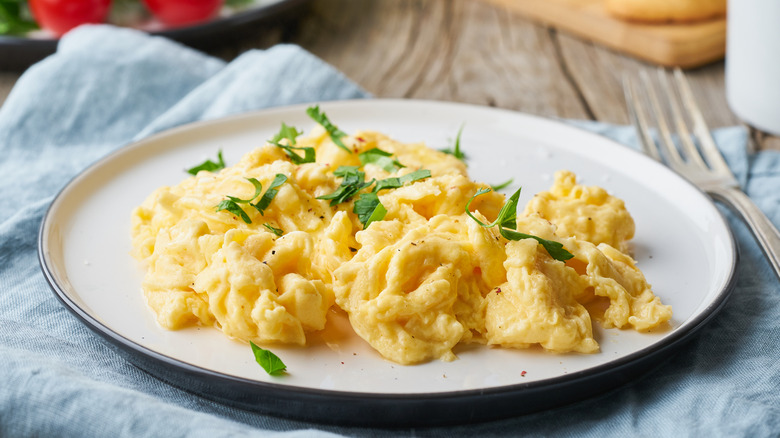 Scrambled eggs are topped with herbs.